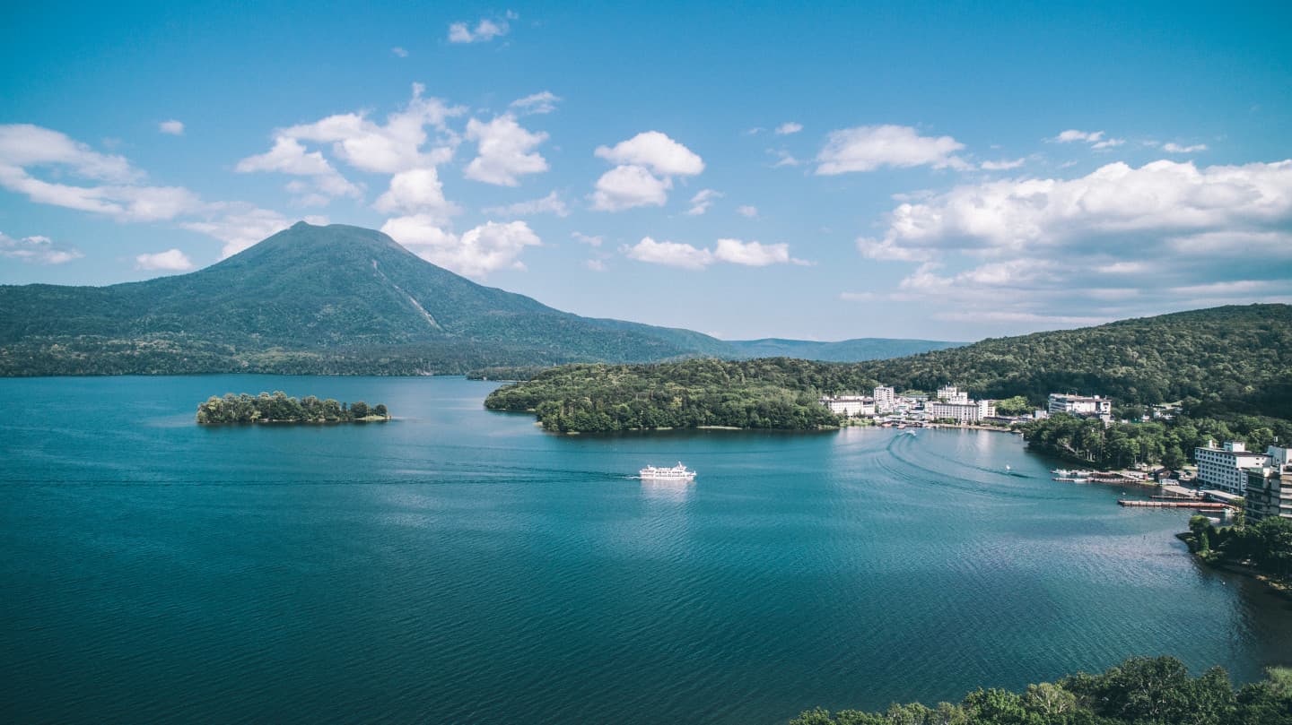 Lake Akan in hokkaido, Japan - A pristine volcanic caldera lake in Akan-Mashu National Park, famous for unique marimo moss balls, hot spring resort town, Ainu cultural experiences, and surrounding volcanic peaks creating dramatic scenery
