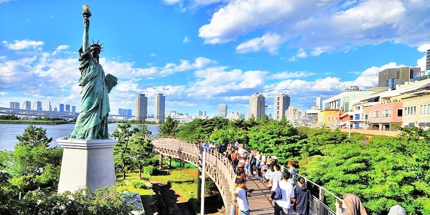 Odaiba Seaside Park Area in tokyo, Japan - A futuristic waterfront district on Tokyo Bay featuring a beach park, Rainbow Bridge views, iconic Gundam statue, shopping complexes, and diverse entertainment in a reclaimed island setting.